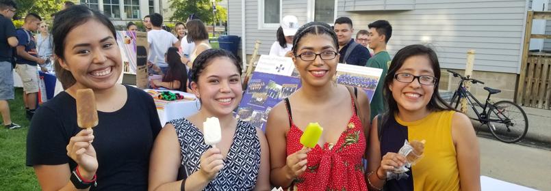 Photo shows 4 young people outside eating frozen popsicles (paletas)