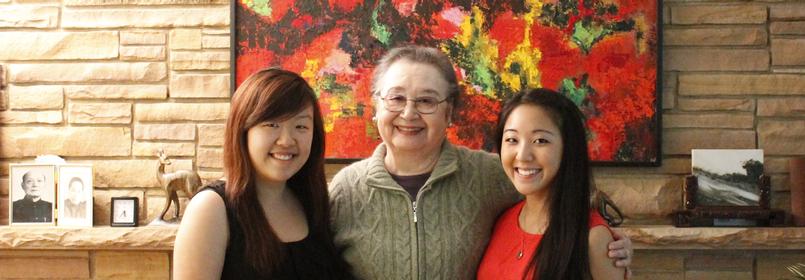 Picture of three people smiling with a colorful piece of art in the background